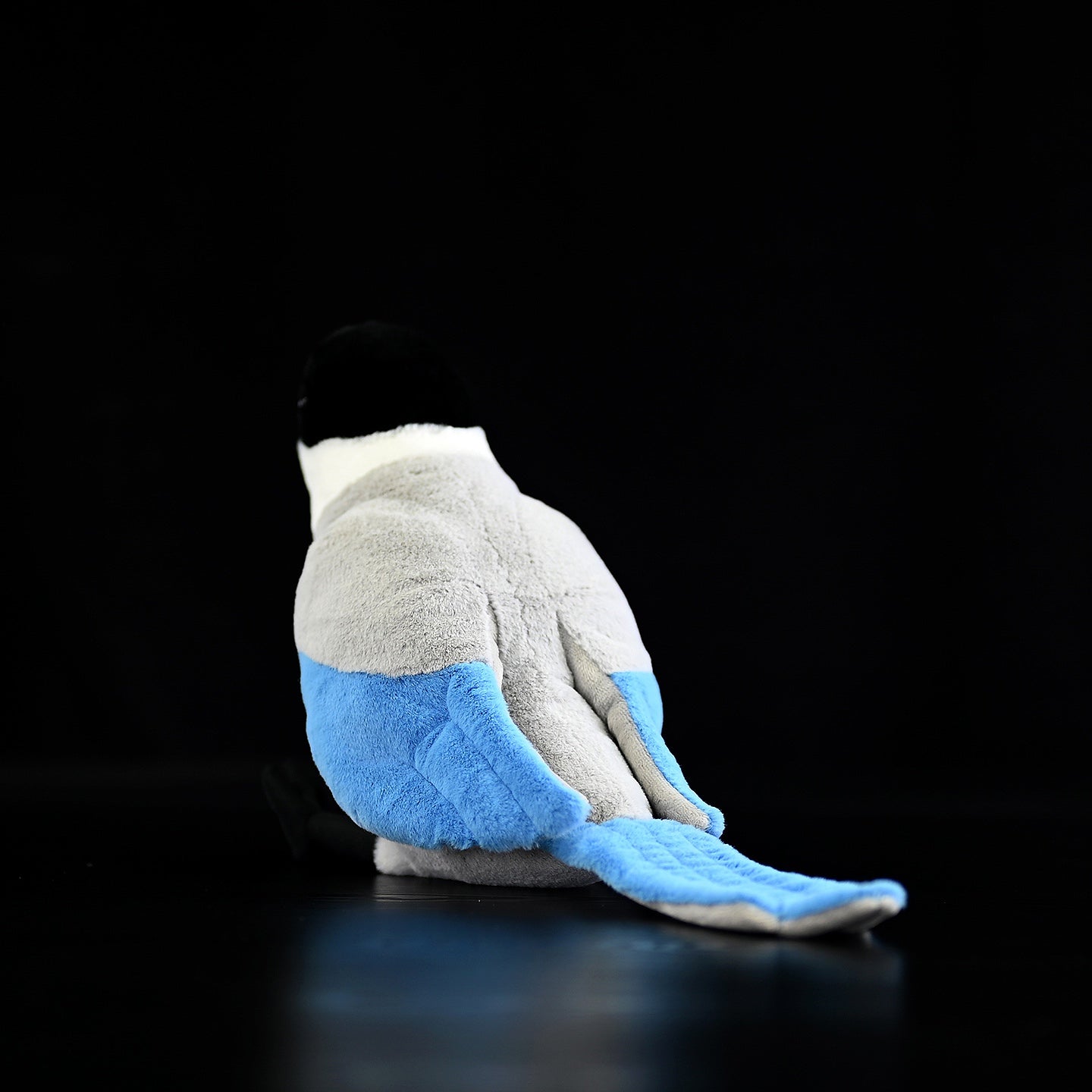 Back view of the azure-winged magpie plush toy, highlighting its long, soft azure tail feathers