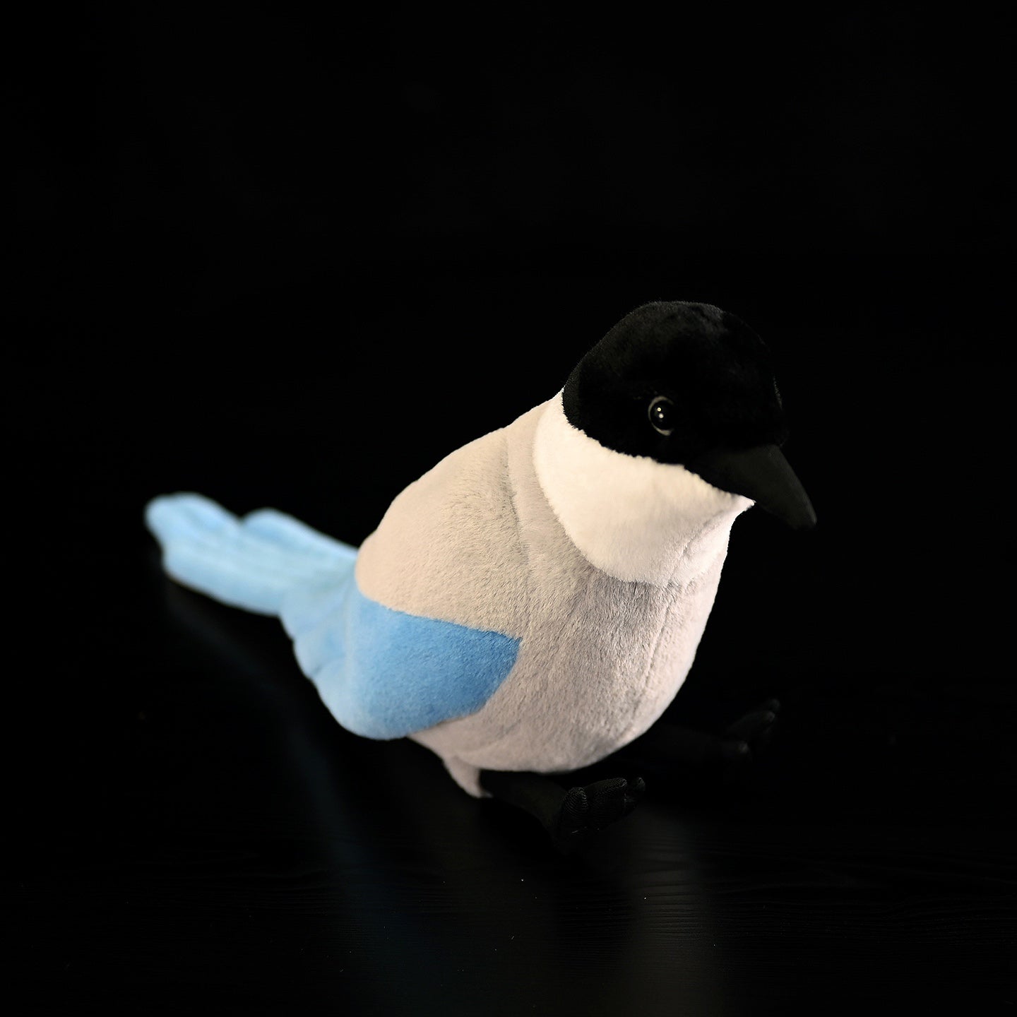 Front view of an azure-winged magpie plush toy with detailed black head and soft body