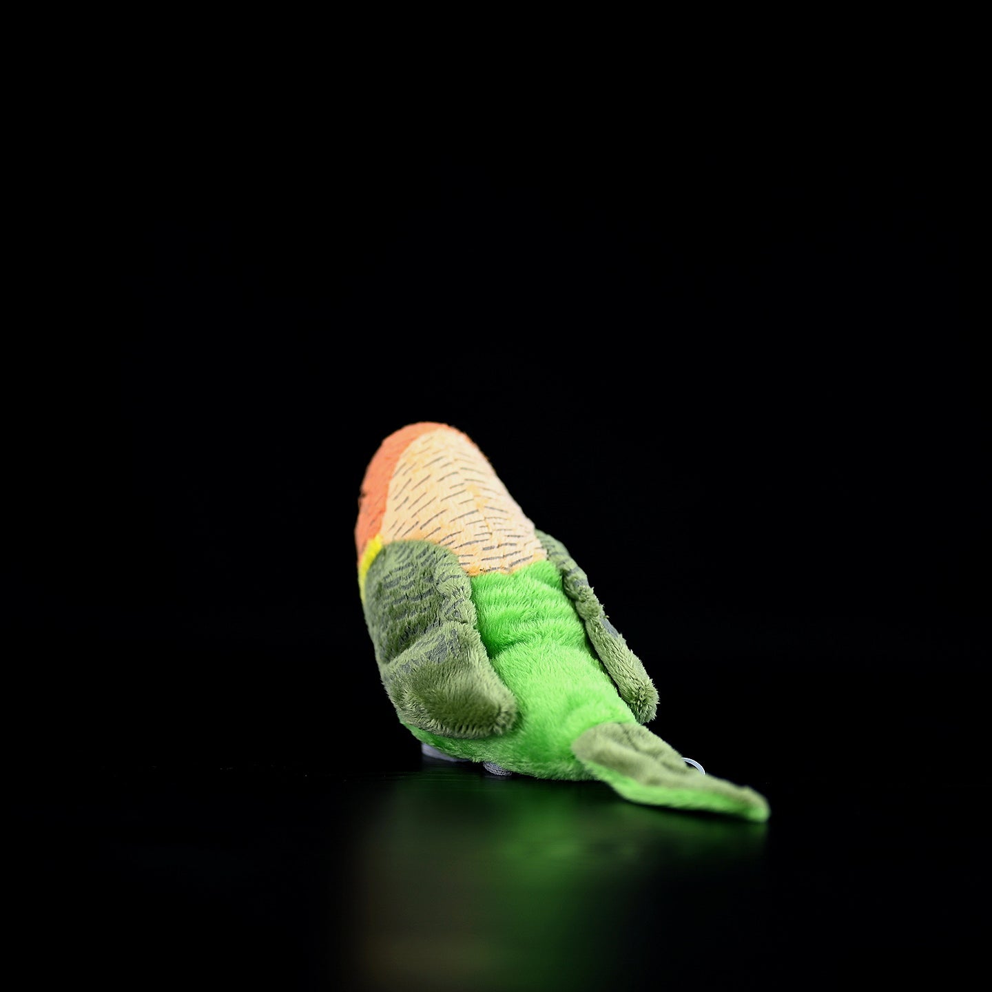 Back view of a Lilian's lovebird plush toy, highlighting its detailed green tail and lifelike design