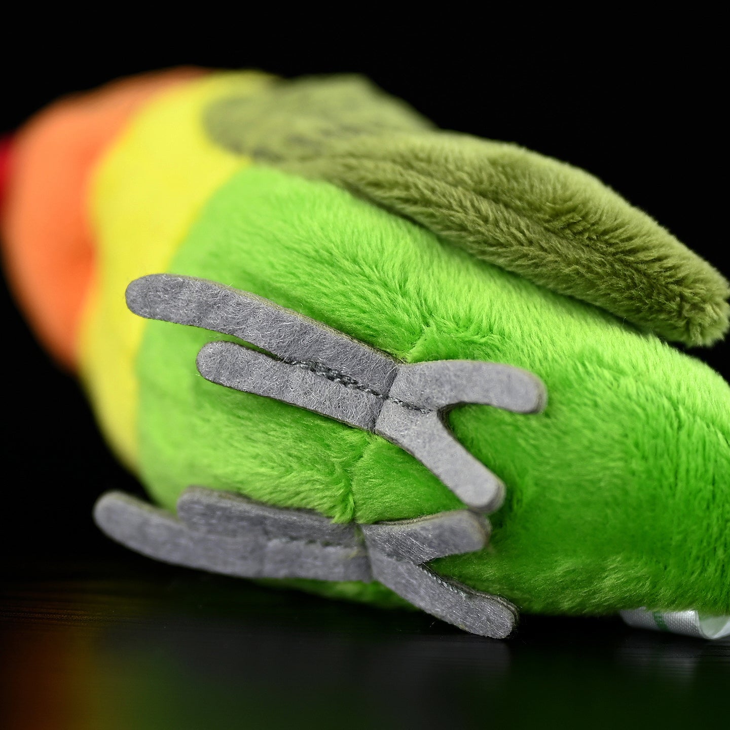 Detail of the plush toy’s legs, mimicking the realistic structure of a Lilian's lovebird's feet