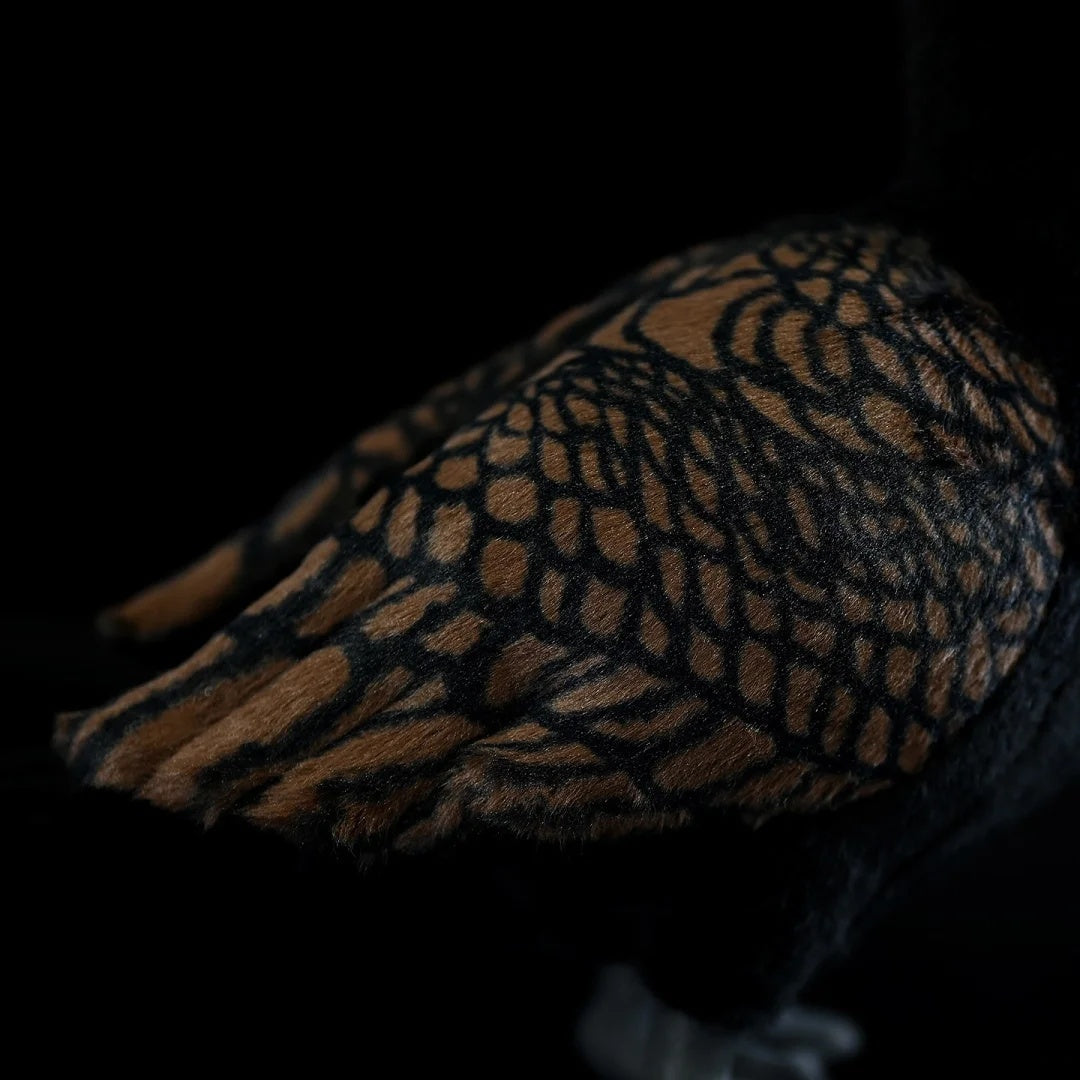Close-up of the detailed wing patterns on a Great Cormorant plush toy, showcasing lifelike craftsmanship