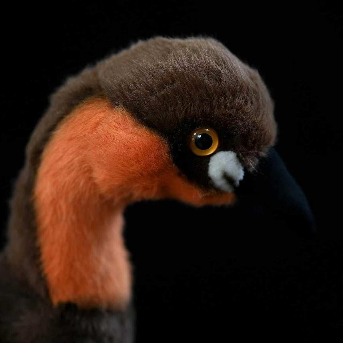 Close-up of Little Grebe plush's lifelike head, featuring vibrant orange and brown details