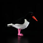 Side view of Eurasian Oystercatcher plush by SoftDaysLab®, featuring black-and-white plumage and pink legs