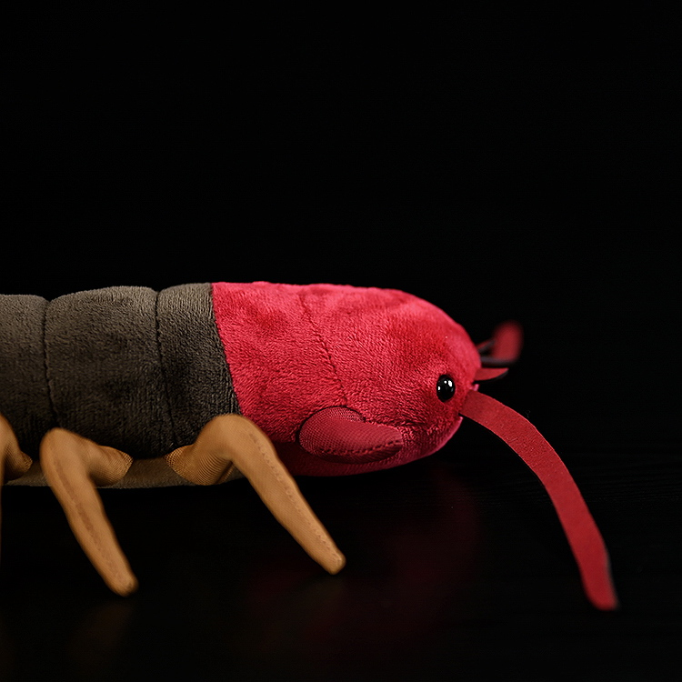 Side profile of the red-head and upper body of Chinese red-headed centipede plush toy, showcasing lifelike features