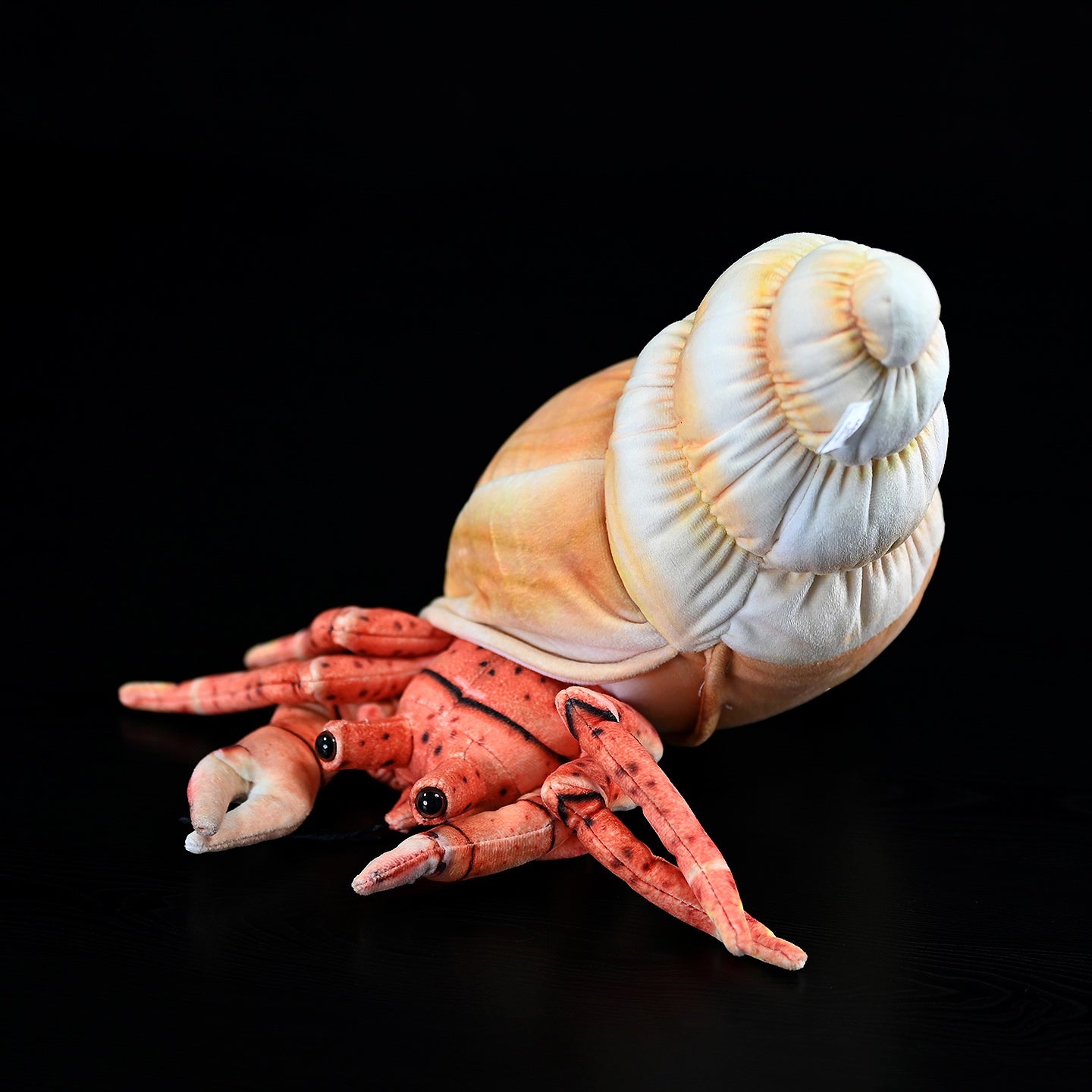 Lifelike hermit crab plush in a resting pose, featuring vivid colors and soft texture