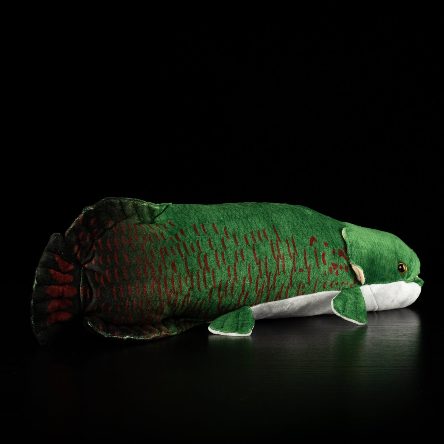 Back view of a lifelike Arapaima gigas plush toy by SoftDaysLab, showcasing detailed green scales and red accents