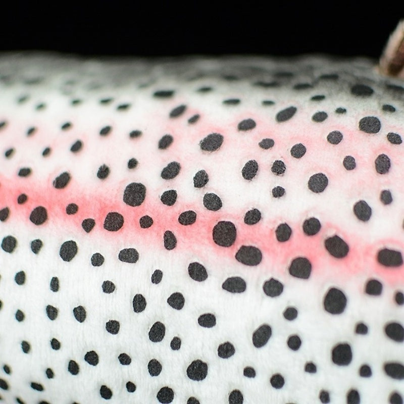 Close-up body pattern of rainbow trout plush toy featuring pink stripe and black spots