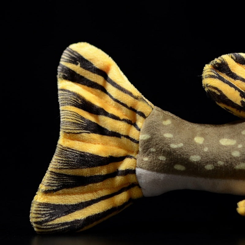 Close-up of northern pike plush toy’s tail fin with bold yellow and black stripes