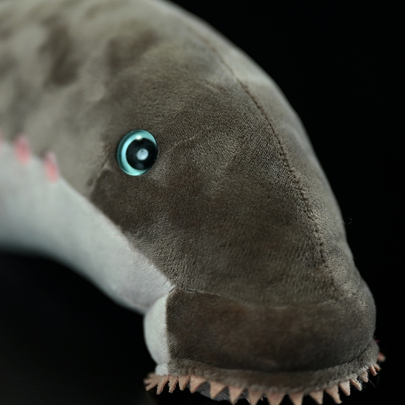 Close-up of sea lamprey plush toy’s face with a vibrant eye and textured head design