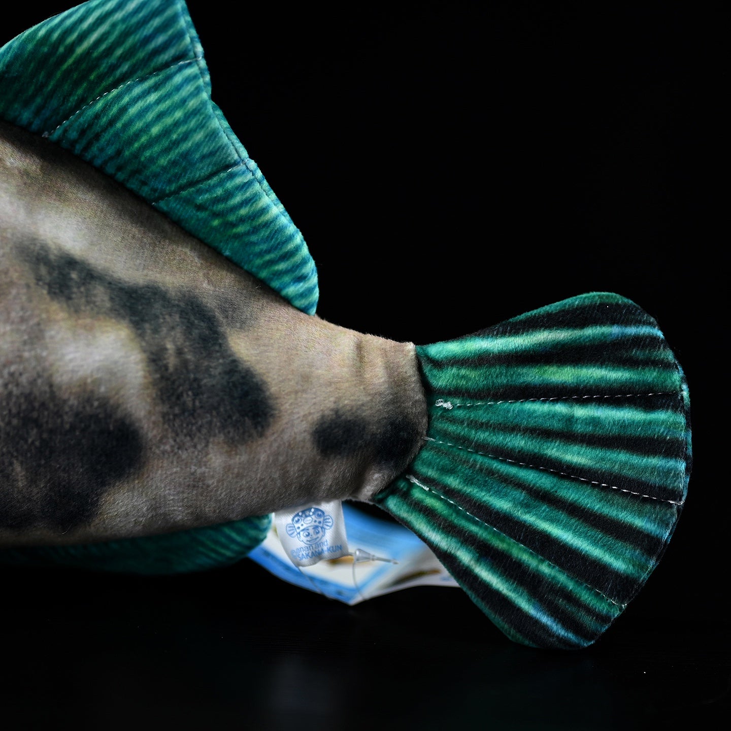 Close-up of Greenfin Horse-Faced Filefish plush toy’s tail fin with vibrant green stripes and soft fabric