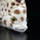 Close-up of the spotted scat plush face, featuring realistic eyes and intricate spot patterns