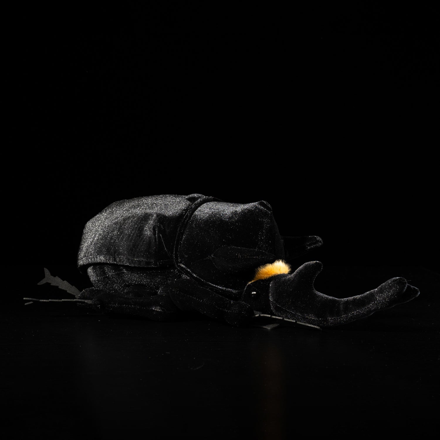Profile view of a Mars rhino beetle plush with realistic black velvet body and orange horn accents by SoftDaysLab