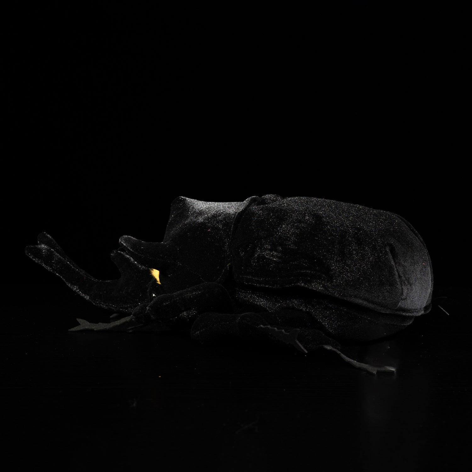Rear view of the Mars rhino beetle plush toy, highlighting its smooth black body and detailed craftsmanship by SoftDaysLab