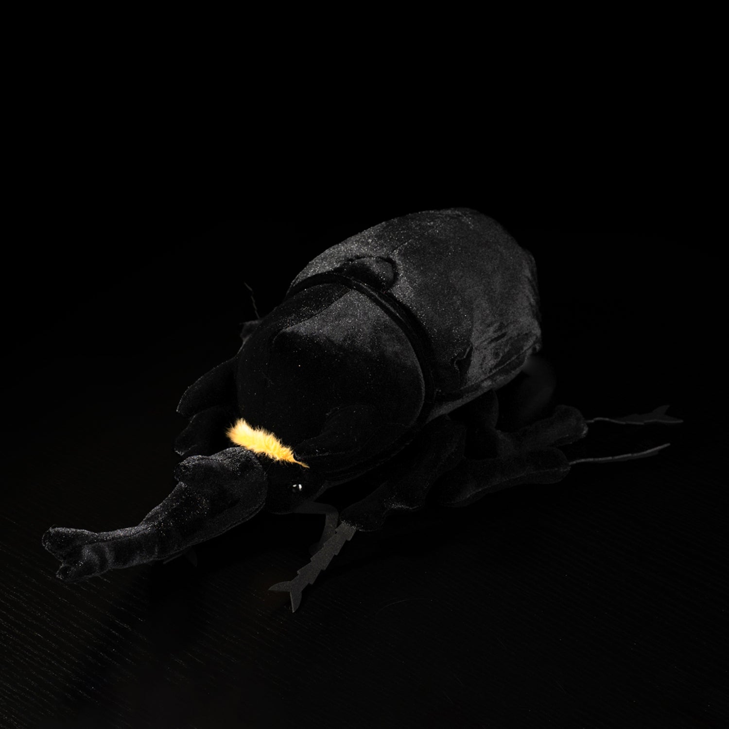 Angled view of a Mars rhino beetle plush toy, highlighting its detailed legs and lifelike design