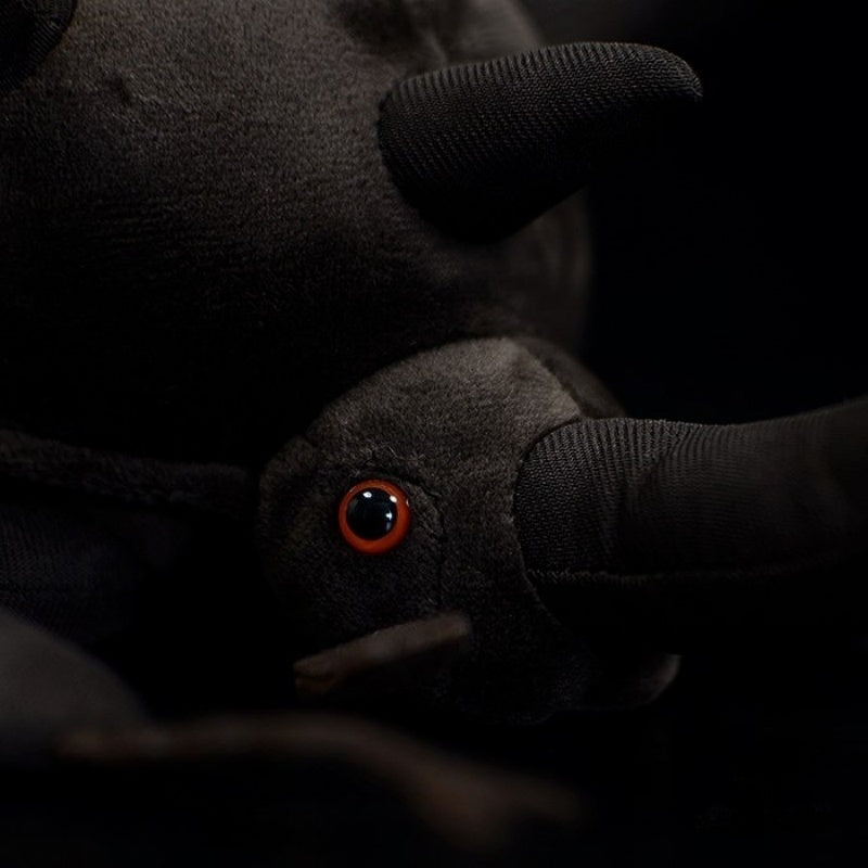 Detailed view of the Atlas beetle plush head, featuring realistic red eyes and soft black fabric by SoftDaysLab