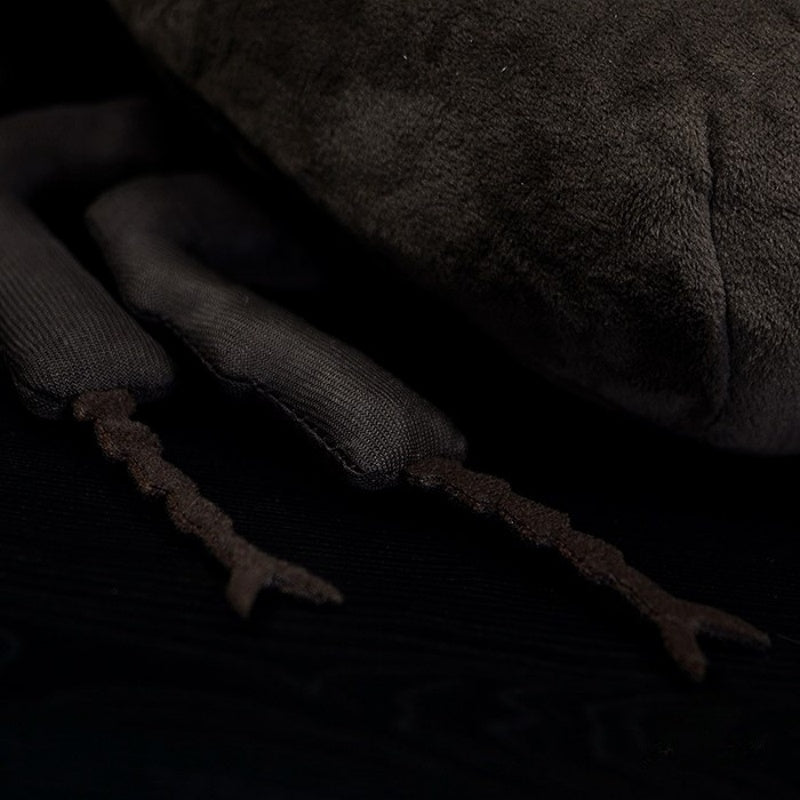 Close-up of the plush toy's legs, highlighting the realistic design and intricate stitching of the Atlas beetle