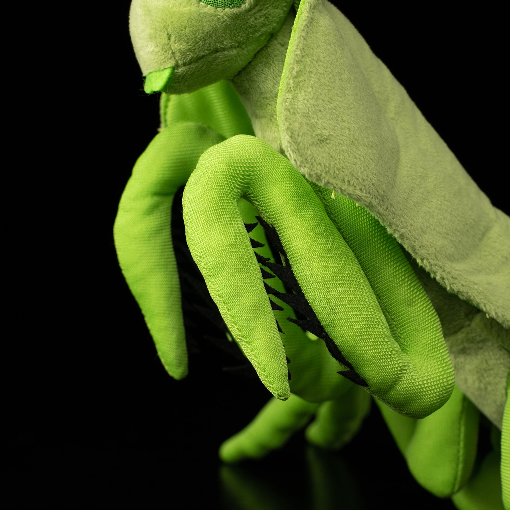 Detailed shot of the SoftDaysLab® leaf mantis plush toy's lifelike front legs with black accents