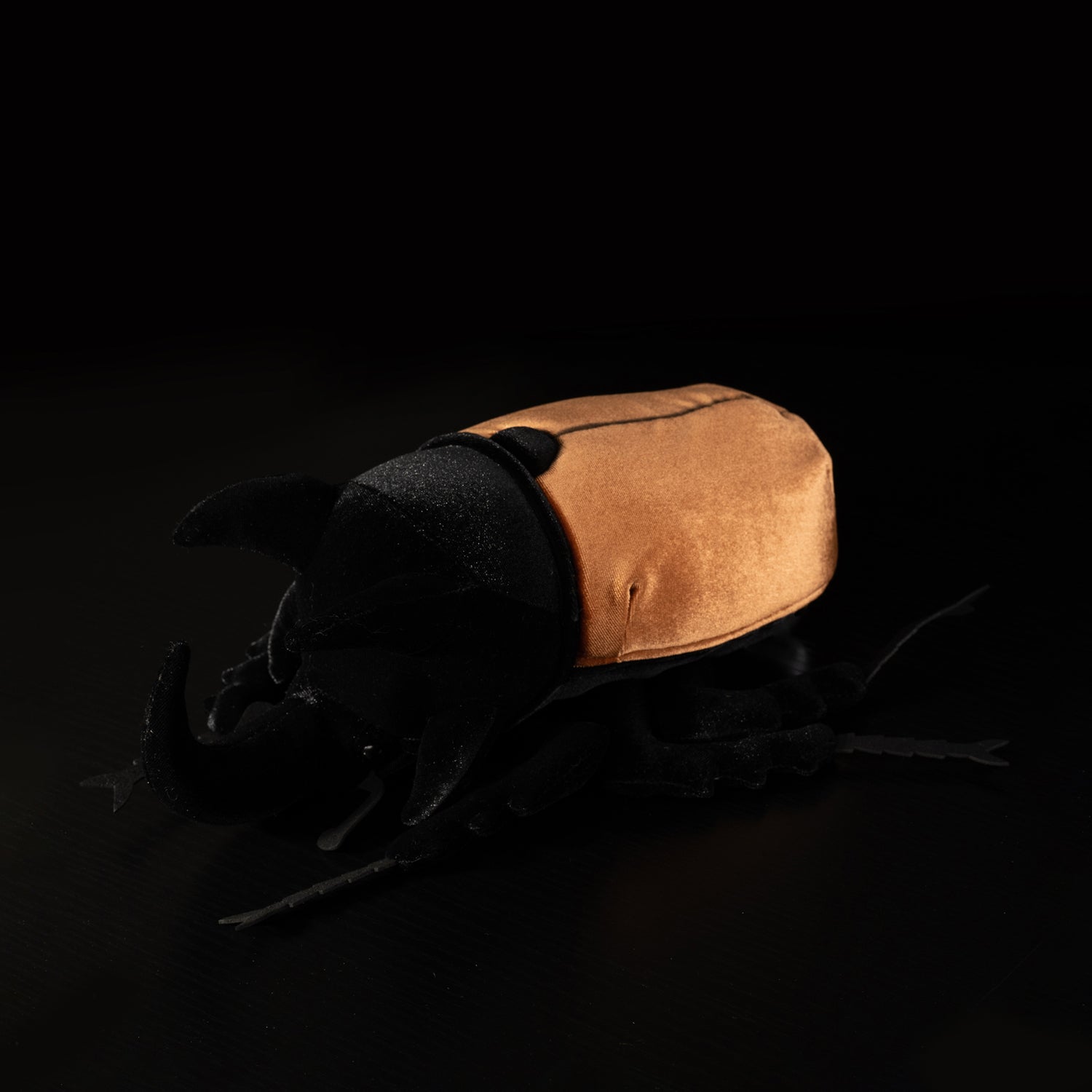 Overhead view of a five-horned rhinoceros beetle plush with detailed horns and lifelike legs