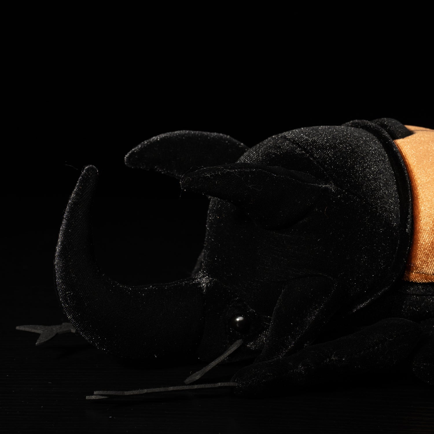 Detailed close-up of the five-horned beetle plush's head, highlighting its lifelike insect features