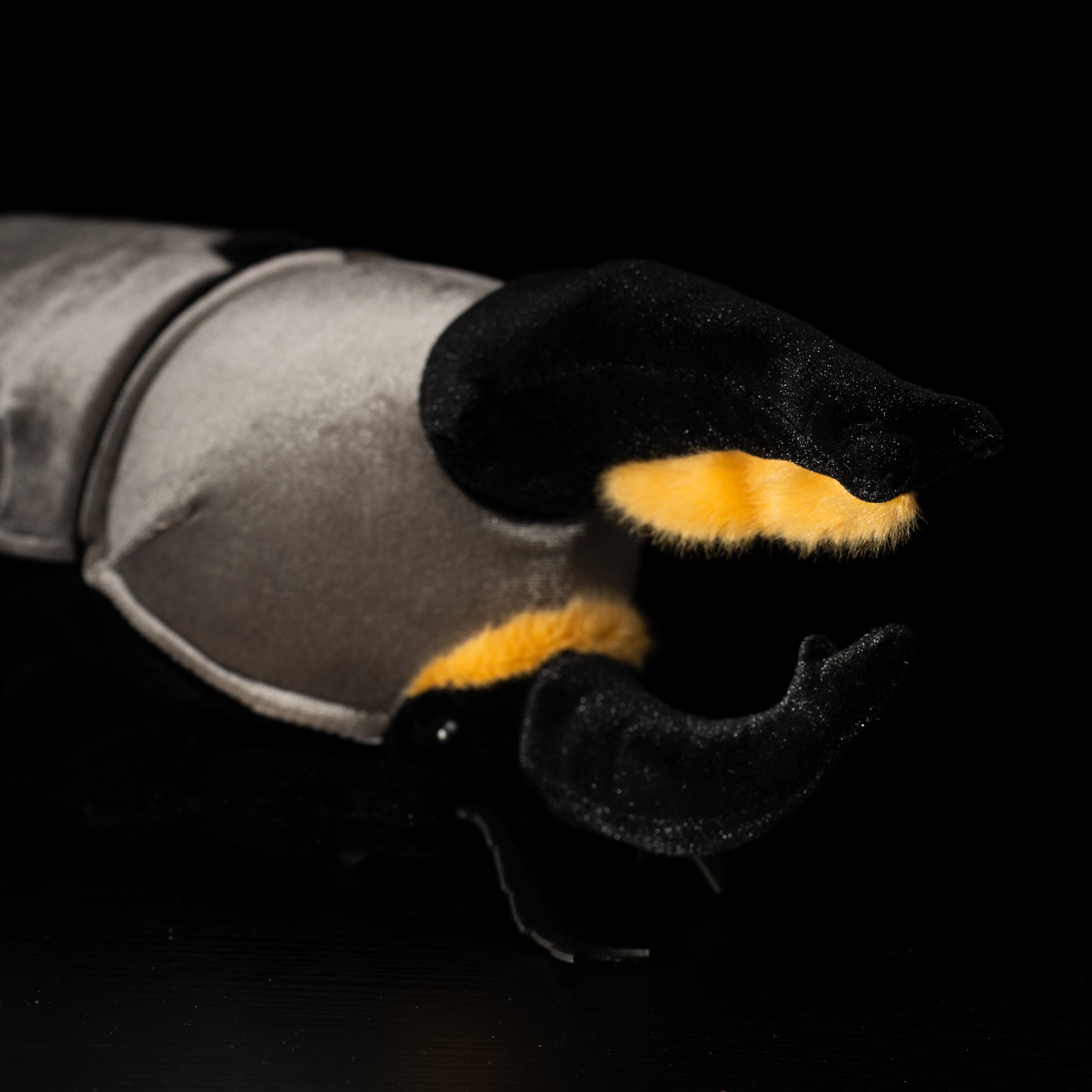 Close-up of plush Western Hercules beetle's black horns with yellow accents, showcasing lifelike design