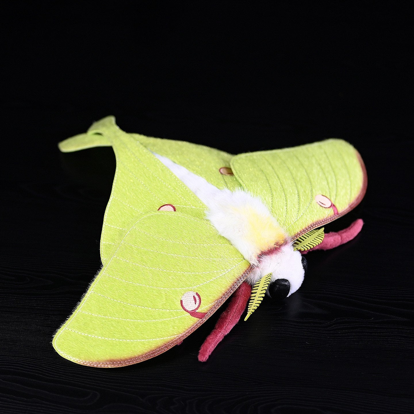 Detailed view of a lifelike American Moon Moth plush with soft texture and intricate wing patterns