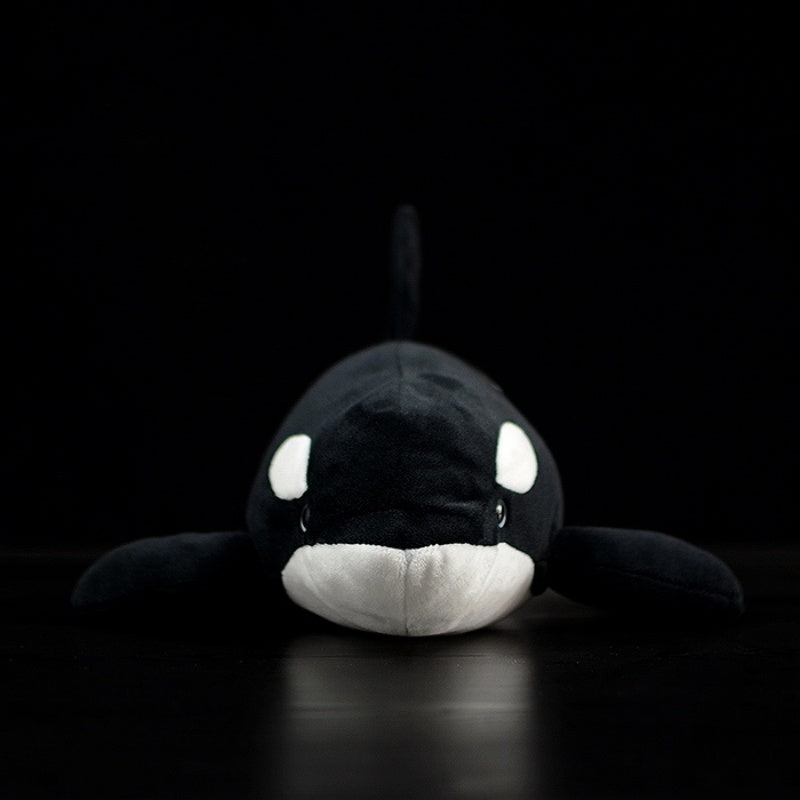 Front view of lifelike orca whale plush toy, showcasing its realistic black-and-white details and soft material