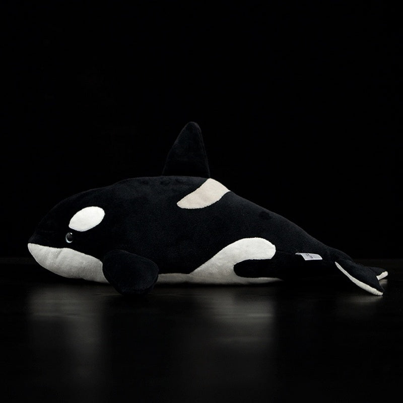 Side profile of a cuddly orca whale plush, designed with precision to replicate the beauty of the real animal