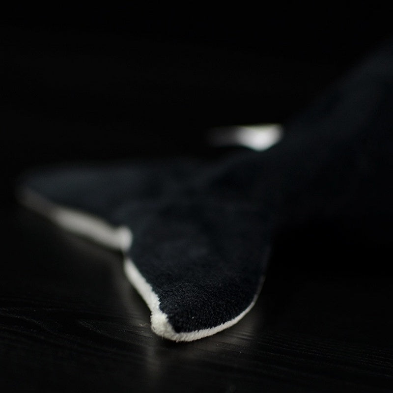 Tail fin detail of the orca whale plush toy, emphasizing its smooth finish and realistic black-and-white pattern