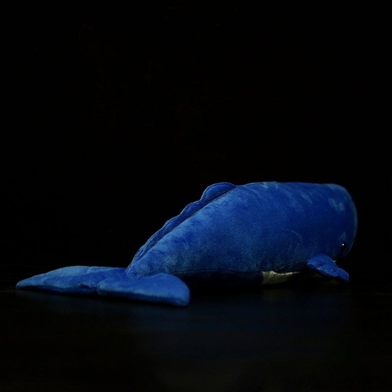 Rear view of the sperm whale plush toy, capturing lifelike tail and body details