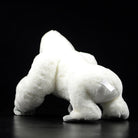 Back view of a white gorilla stuffed animal, highlighting its fluffy texture and lifelike posture