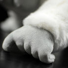 Close-up of the albino gorilla plush toy’s hand, highlighting the soft, detailed design