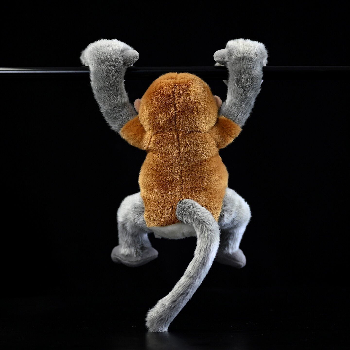 Back view of hanging Proboscis Monkey plush, showcasing its detailed fur and jungle-inspired design
