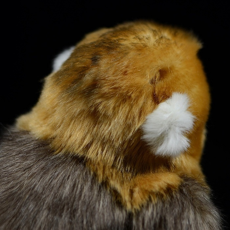 Close-up of a golden snub-nosed monkey plush toy’s ear and fur texture, showcasing intricate craftsmanship