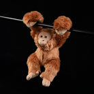 Realistic orangutan plush toy hanging, perfect for animal-themed decor or cuddly companionship
