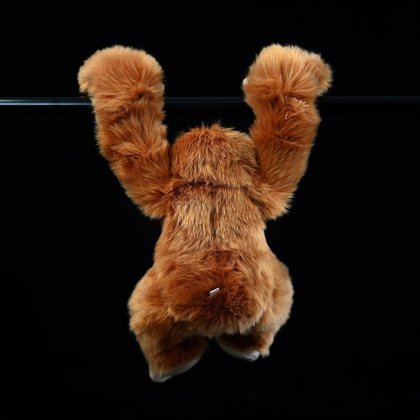 Back view of orangutan plush toy hanging, showing soft fur and realistic details for jungle enthusiasts