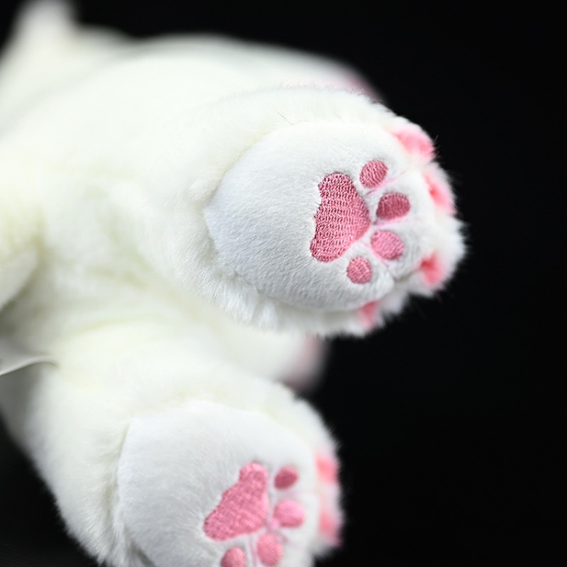 Close-up of the pink paw pads of a standing ermine plush toy, adding realistic detail