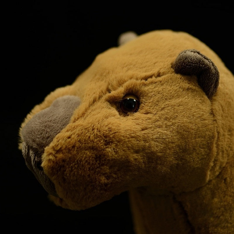 Side close-up of a realistic capybara plush toy’s head showing lifelike details and ears