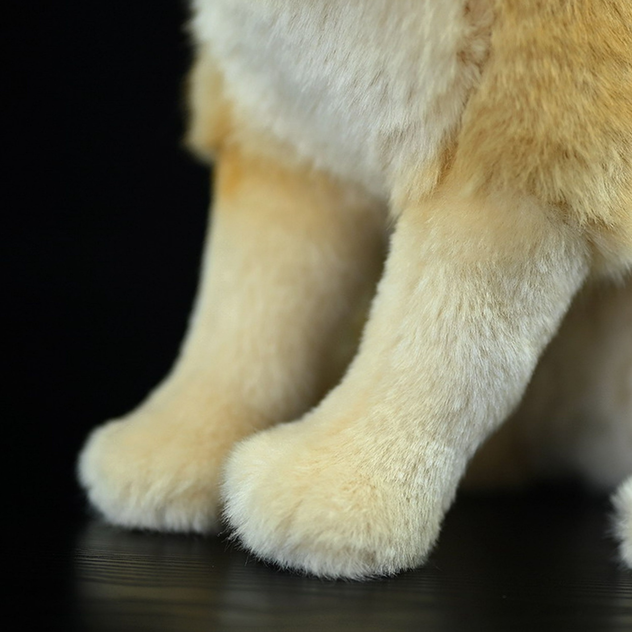 Close-up of the plush front legs of a fennec fox toy showing soft texture and realistic design