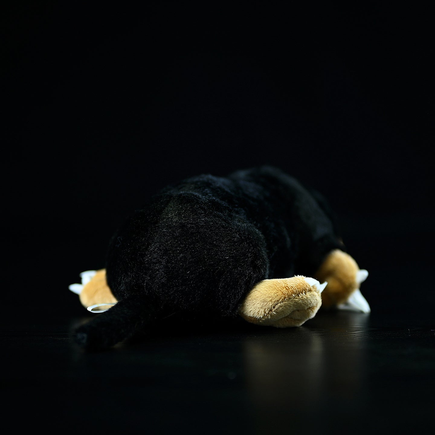 Back view of a lying mole plush toy, highlighting its soft texture and detailed tail design