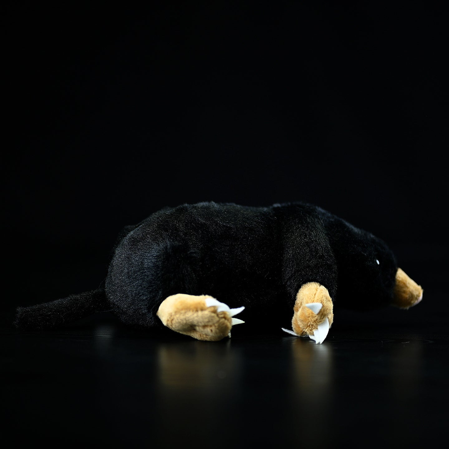 Back view of a lying mole plush toy, highlighting its soft texture and detailed tail design