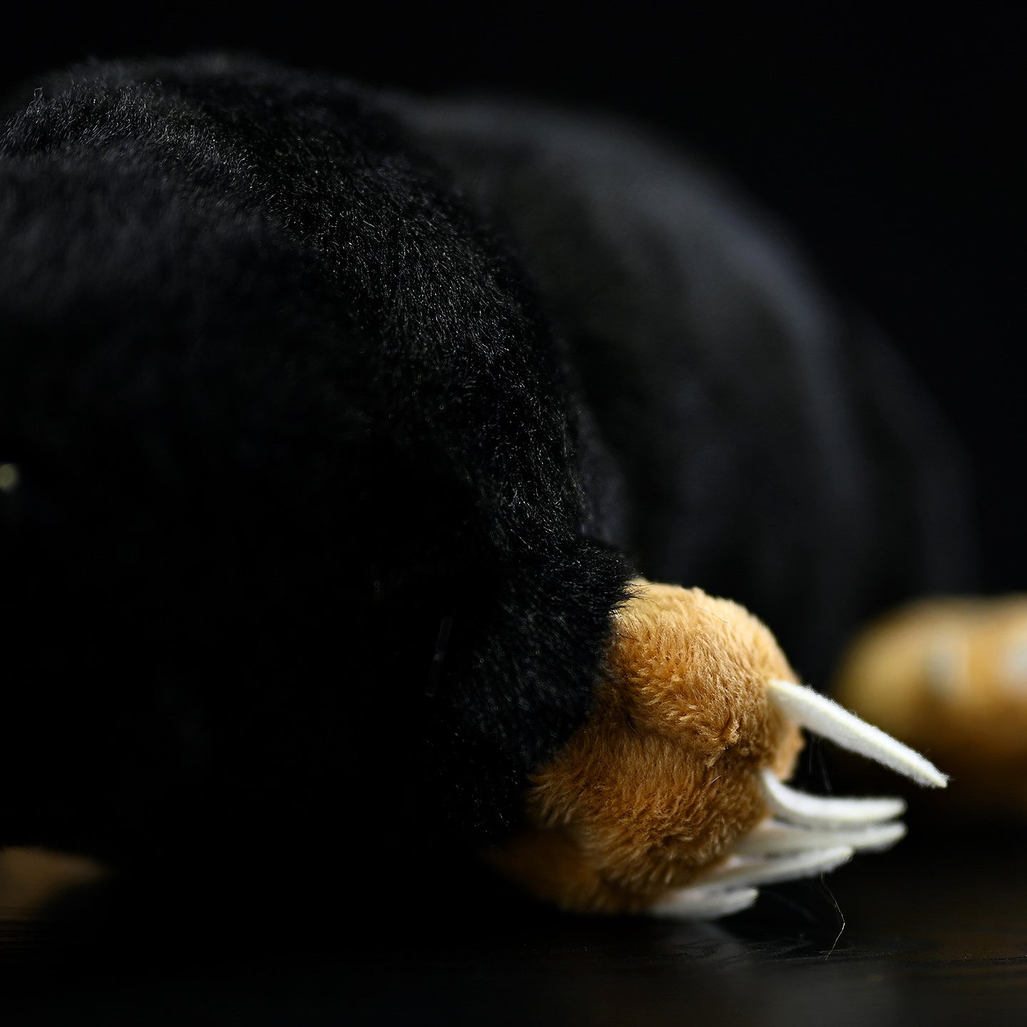 Close-up of the mole plush toy's paw, highlighting its realistic claw detail and soft fabric texture