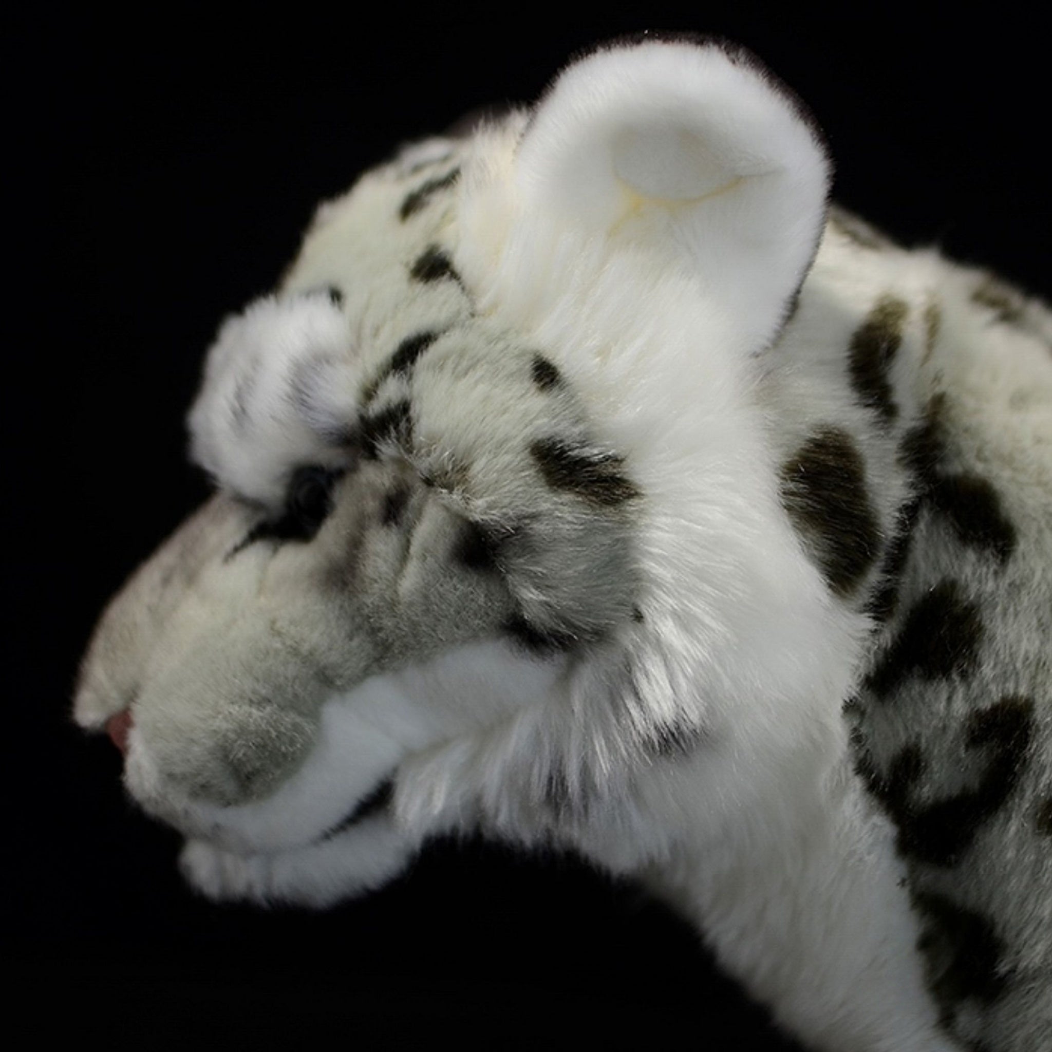 Side profile of snow leopard plush toy with detailed fur patterns and lifelike craftsmanship