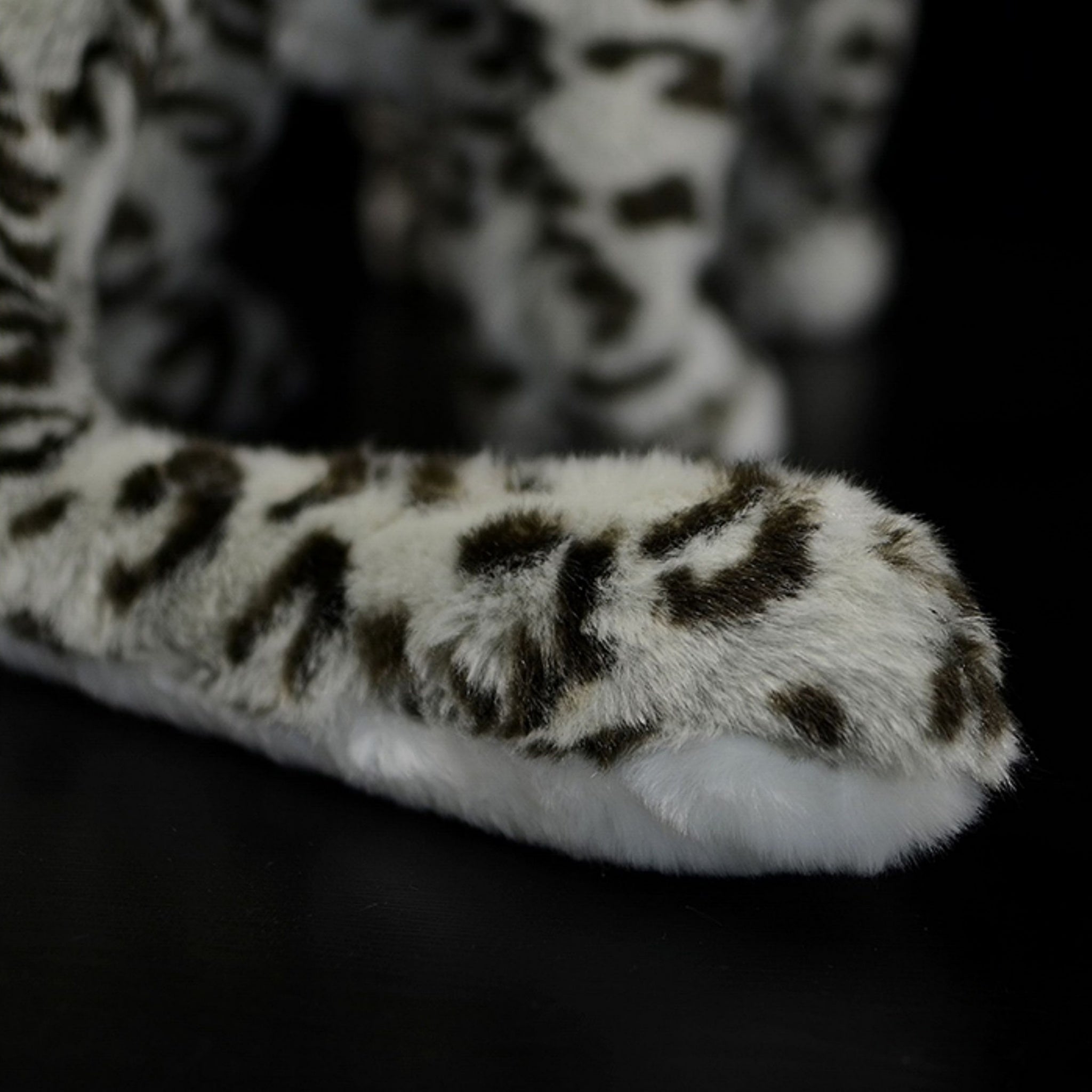 Tail of snow leopard plush toy with realistic fur patterns and soft texture