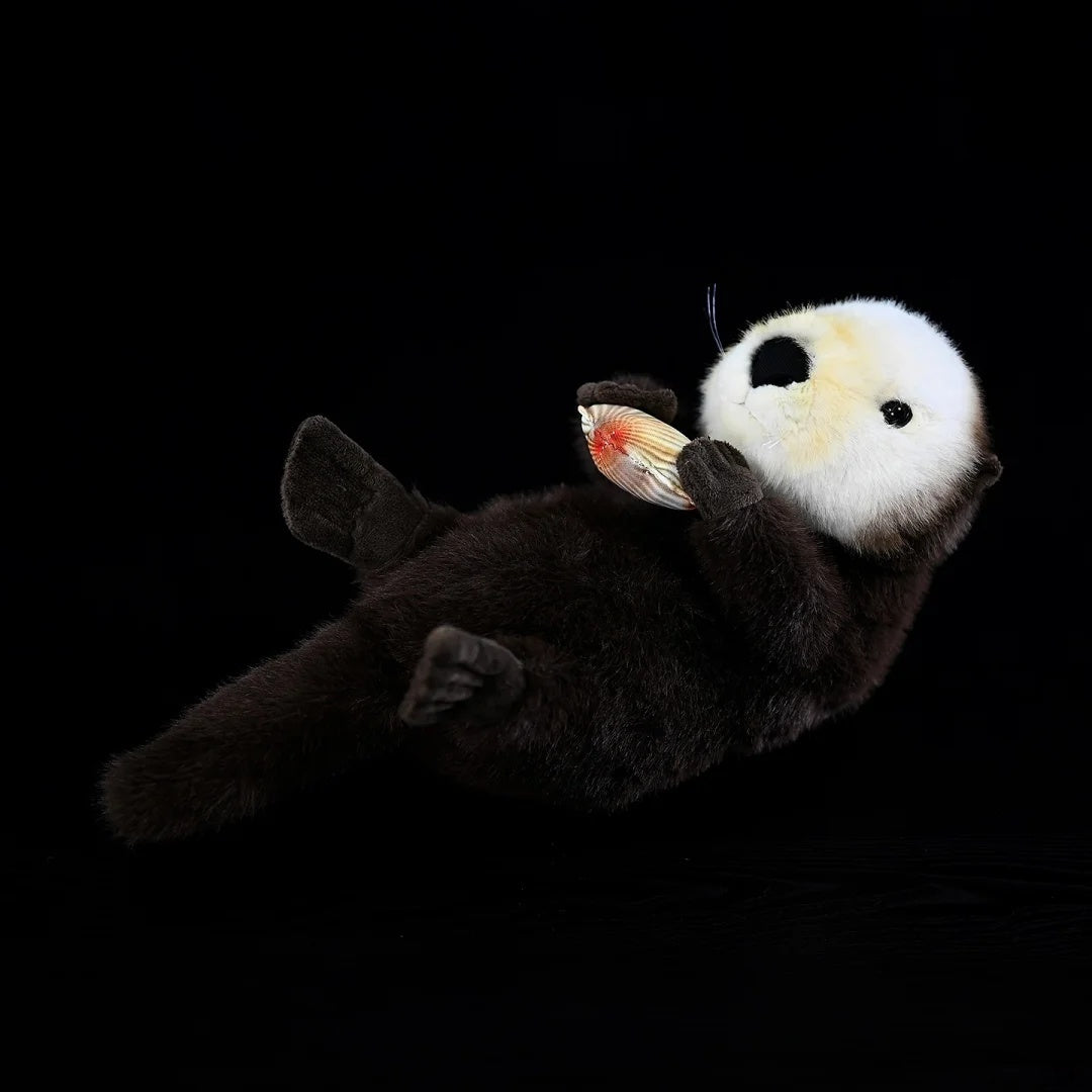 SoftDaysLab® sea otter plush floating on its back, holding a detailed clam in adorable paws