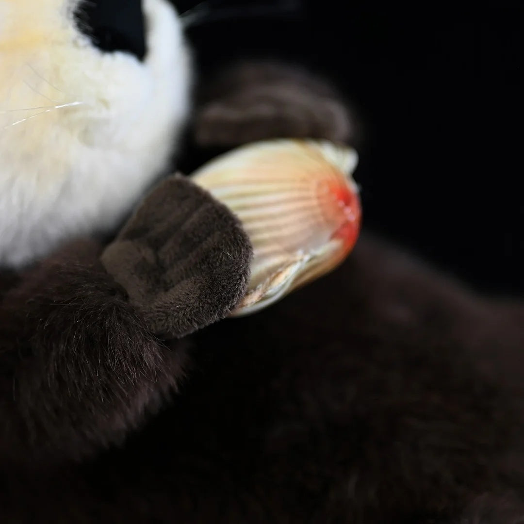 Detailed shot of SoftDaysLab® sea otter plush’s paw grips, securely clutching the vibrant realistic clam toy