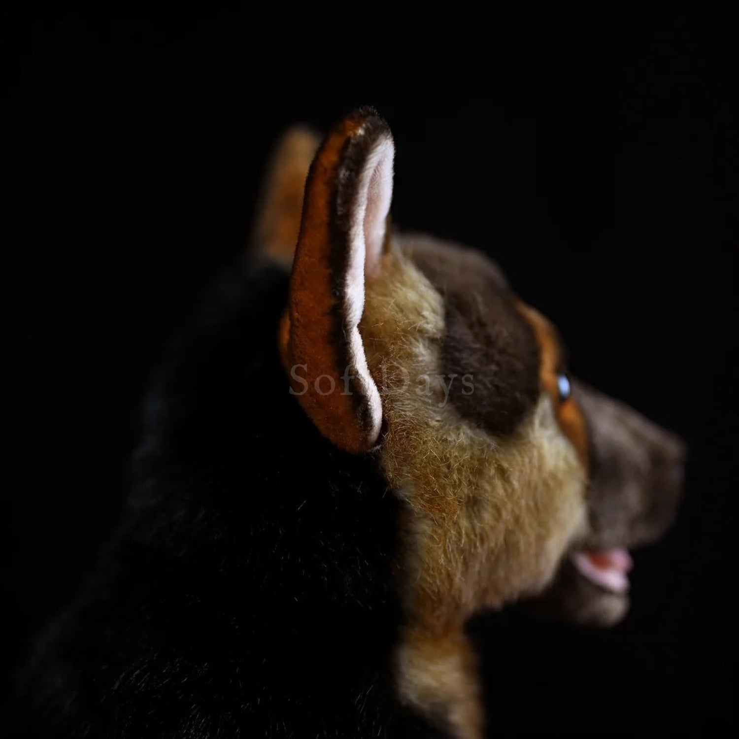 Detailed side view of a realistic German Shepherd plush toy, highlighting its lifelike fur and finely crafted ears