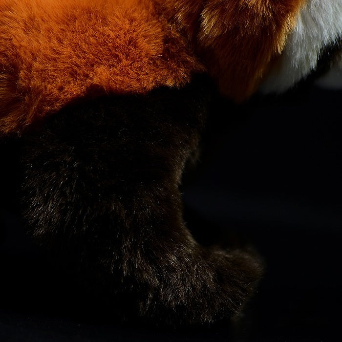 Close-up of the red panda plush toy's fur texture, showcasing its soft and vibrant orange and brown colors