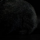 Back texture detail of the black rat plush toy, showing realistic fur and lifelike stitching