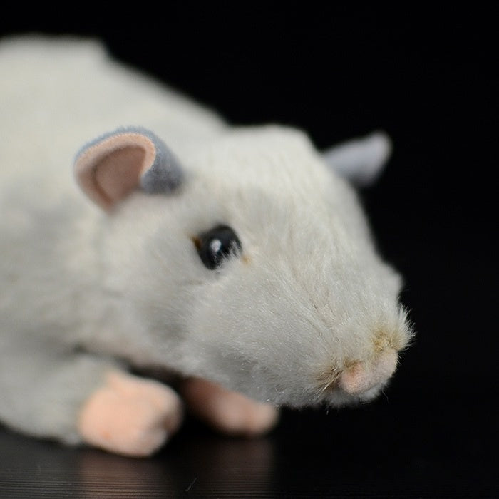 Close-up of a grey mouse plush toy's face, highlighting its realistic eyes and soft fabric texture