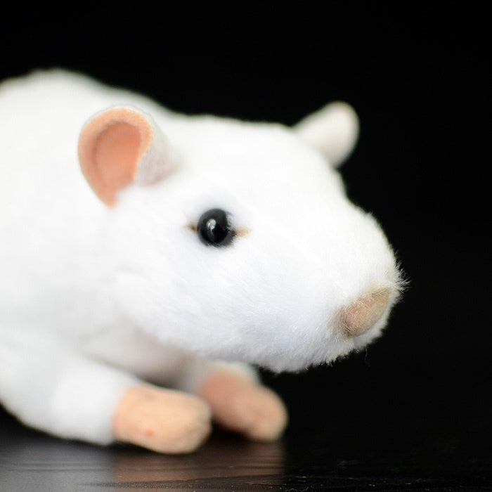 Close-up of the white lab mouse plush toy's face, highlighting lifelike eyes and soft material